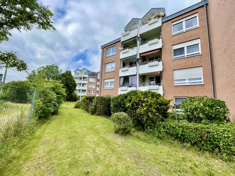 Wohnanlage der vermieteten Terrassenwohnung in Schkeuditz, umgeben von Rasenflächen und Hecken